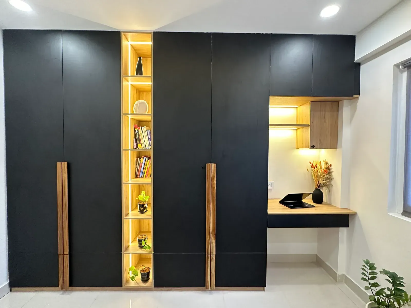 Black wardrobe with lit oak display column and study desk — The Aakar